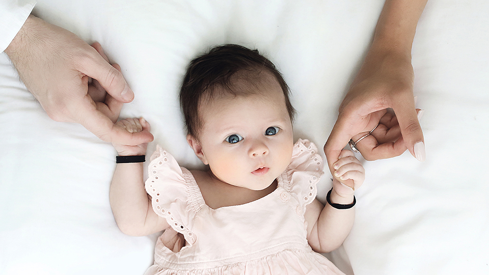 Baby holding parents hands photogragraphy